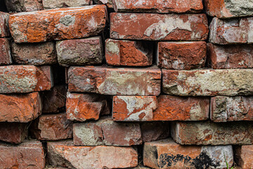 Texture of old red bricks. Stacked old red bricks as background for your image. Construction material.
