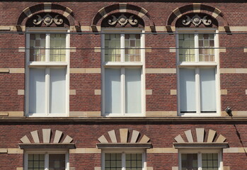 Fototapeta premium Amsterdam Nieuwezijds Voorburgwal Street Building Facade Close Up with Windows and Sculpted Details, Netherlands