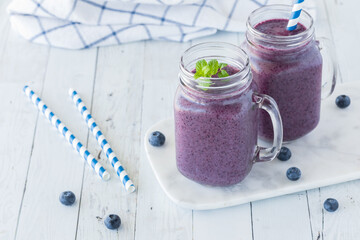 Jars of creamy blueberry smoothies ready for drinking.