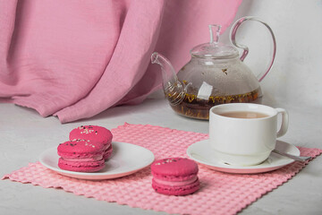 breakfast of herbal tea with lavender and sweet colorful dessert macarons on white background