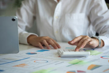 Team of business women use calculators and graph analysis computer laptop tablets to plan marketing strategies and make profitable investments for the company.