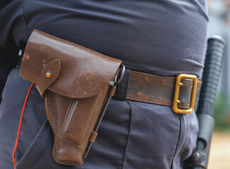A law enforcement officer wears a duty belt, with a pistol, handcuffs, a baton. selective focus....