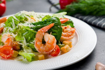 salad caesar with shrimps on white plate macro close up