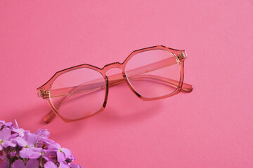 eyeglasses on bright pink background, trendy eyeglass frames copy space