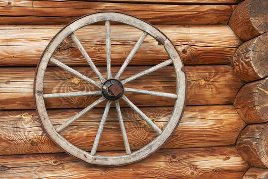 An old wooden cart wheel as an element of modern decor. Copy space. © ROMAN DZIUBALO