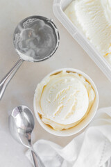 Vanilla ice cream in white cup, marble background