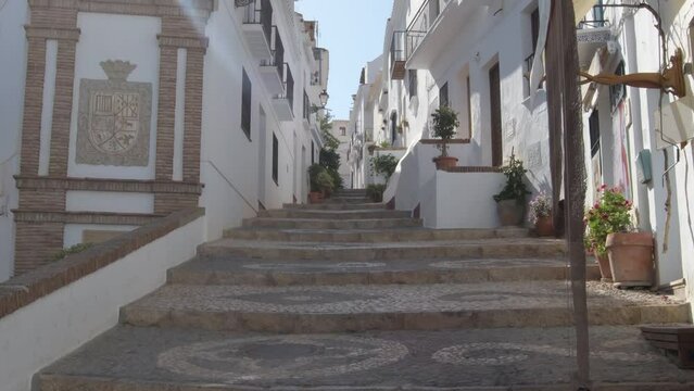 Andalusian white street a sunny evening, Frigiliana, Spain. Tilt