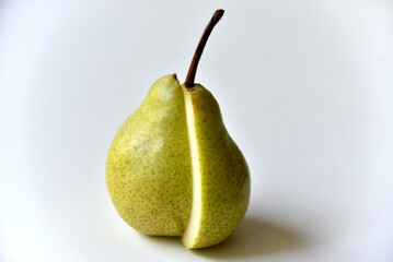 Sliced green pear in half on a white background
