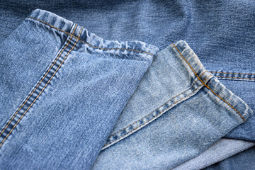 Fototapeta premium Lots of jeans pants in a stack. Denim background.