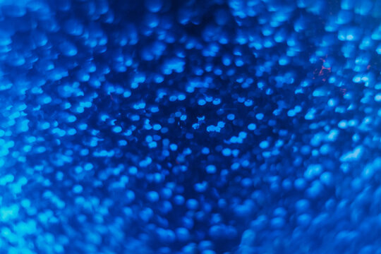 Blur sequin texture. Neon bokeh light. Futuristic radiance. Defocused ultraviolet navy blue color circles glow on black decorative abstract background. - Powered by Adobe