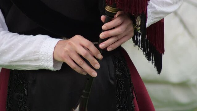 Woman in period dress playing a bagpipes