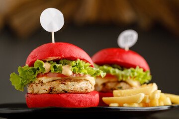 Mini chicken Burger with fries served in a dish isolated on grey background side view fast food