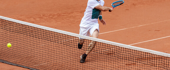 Male tennis player in action on the court on a sunny day. Professional sport concept. Horizontal...