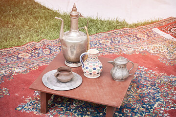 Tea ceremony at the Crimean Tatars, a table with a teapot, cups and food on red carpets