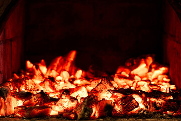 Wood heating in countryside, embers glow in wood burning stove.