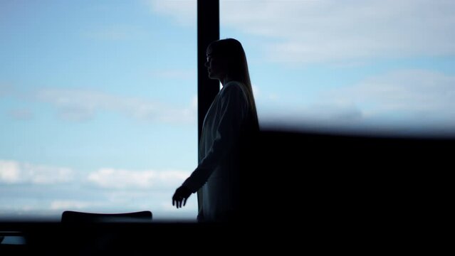 Woman silhouette going glass office room. Confident manager walking office alone