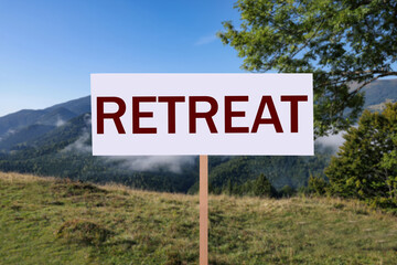 Wooden sign with word Retreat and beautiful view of mountain landscape