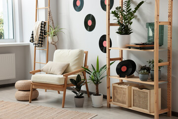 Living room interior with stylish turntable on wooden shelving unit and vinyl records