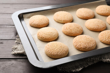 Baking sheet with delicious sugar cookies on wooden table, closeup