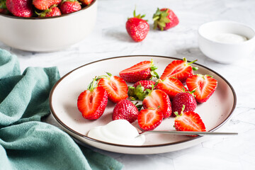 Fresh sliced strawberries and yogurt on a plate on the table. Healthy vitamin dessert. - Powered by Adobe