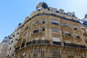 Fototapeta na wymiar The facades of traditional French houses with typical balconies and windows. Paris.