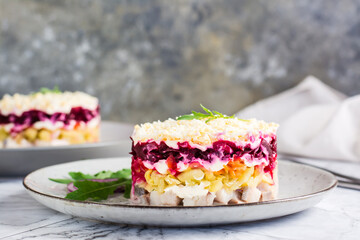 Herring under a fur coat traditional Christmas salad on a plate on the table