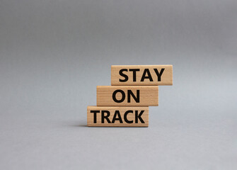 Stay on track symbol. Wooden blocks with words 'Stay on track'. Beautiful grey background. Business and 'Stay on track' concept. Copy space.