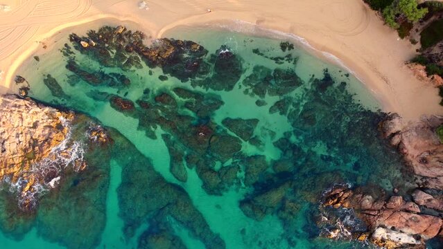 Aerial view of Sa Conca beach, Costa Brava, Catalunya, Mediterranean sea coast, Spain. Beach background with transparent turquoise blue water. Summer tourism. Beach vacations. 4k drone video.