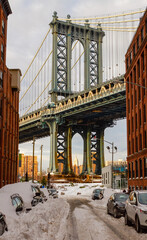 View of the Manhattan Bridge through a snow covered street