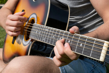 Fototapeta na wymiar Guy play the guitar. Closeup