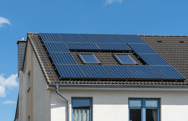 solar panels of a photovoltaic power plant on the roof of a black tiled house