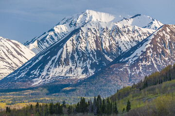 Fototapeta na wymiar Winter landscape in northern Canada with snow capped mountains surrounding wilderness setting in Carcross, Yukon Territory during late winter early spring April.