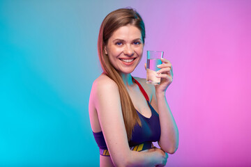 Smiling sporty woman in sportswear with water glass. Female fitness portrait isolated on neon multicolor background.