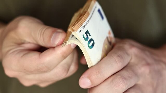 Man Counting Money. Close up of male hands counting pile of 50 euro banknotes. Euro currency exchange. Cash money calculation. Concept of salary