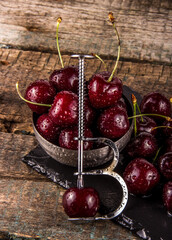Cherry Pitter. Bowl of juicy cherries. Cherry pitting tool