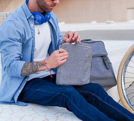 Young caucasian man closing laptop sleeve.