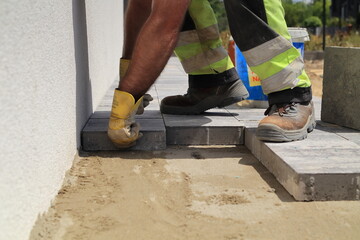 The paver places the paving stones on the prepared substrate.
Na przygotowane podłoże brukarz układa kostkę brukową.