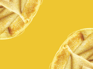 Crêpes in two corners on yellow background. Place for text or slogan. 