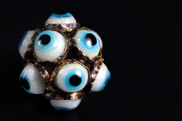 amulet full of eye symbols. necklace close-up. black background. macro