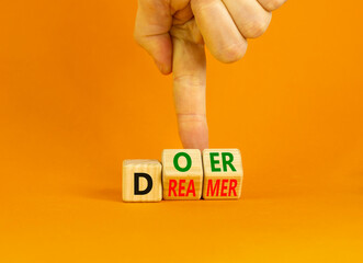 Doer or dreamer symbol. Concept words Doer or dreamer on wooden cubes. Businessman hand. Beautiful...