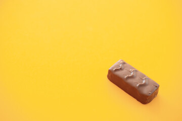 Chocolate candy bar on yellow background