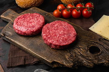 Raw fresh large beef burger on old dark  wooden table background
