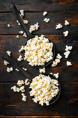 Obraz na płótnie Canvas Heap of salted popcorn on old dark wooden table background, top view flat lay
