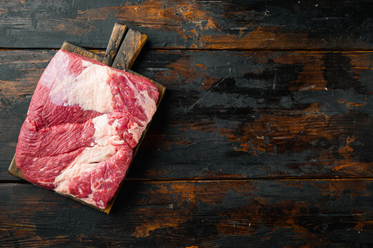 Raw brisket beef cut. Black Angus beef, on old dark  wooden table background, top view flat lay,  with copy space for text