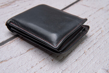 black leather wallet on wooden table side view