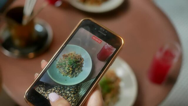 Women's hands take pictures of food for dinner using a smartphone. Close-up. 4K.