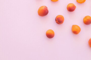 Fototapeta na wymiar Delicious ripe sweet apricots on pink background, flat lay.