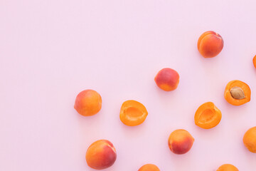 Fototapeta na wymiar Delicious ripe sweet apricots on pink background, flat lay.