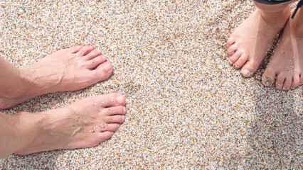 Child and woman feet on the beach sand