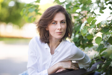 middle aged woman relaxed outdoors. copy space. Slow life. Enjoying the little things. spends time in nature in summer